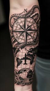 Forearm tattoo with compass rose, rope wrapping, world map, airplane silhouette, black and gray shading.