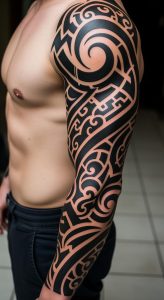 Muscular arm with bold black full-sleeve tribal tattoo, swirling patterns, smooth shading, close-up view.