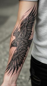 Dynamic abstract blackwork raven tattoo in mid-flight on muscular forearm, textured shirt, gritty concrete background.